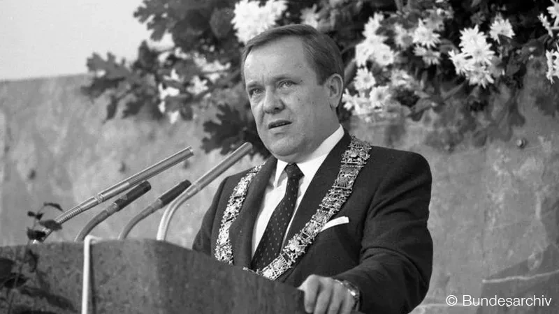 Black and white photograph of Minister Walter Wallman giving a speech