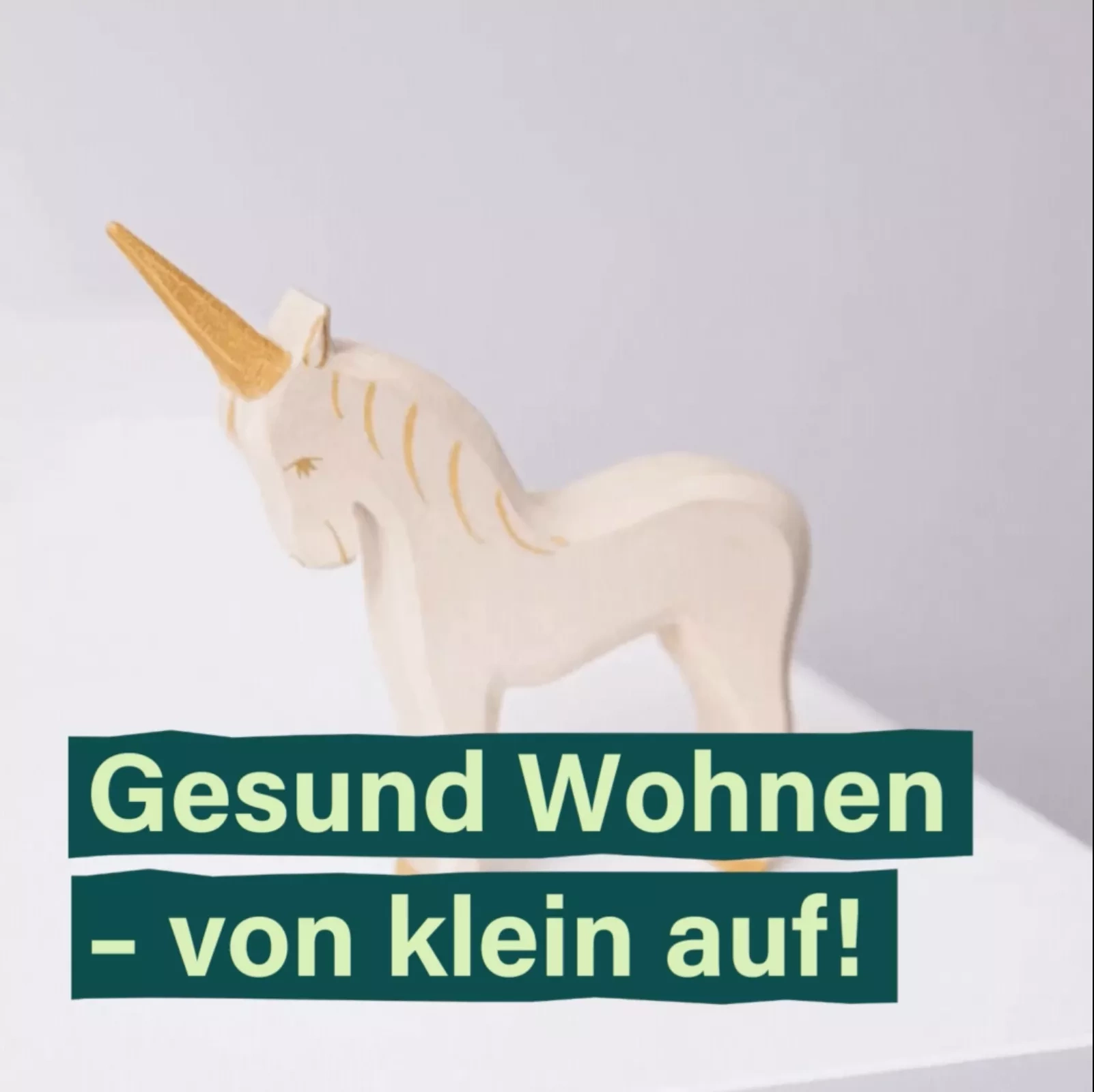 Holzspielfigur bewegt sich auf einem Tisch hoch und runter. Davor steht in grüner Schrift: Gesund Wohnen - von klein auf!