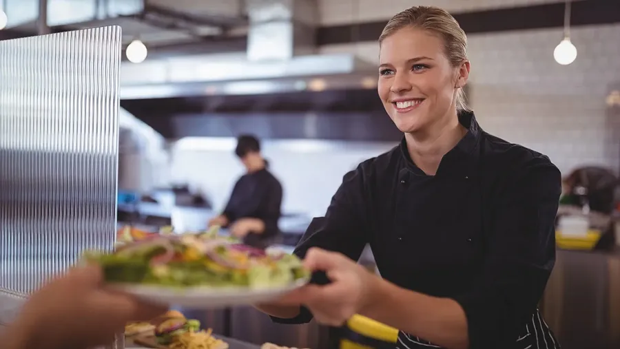 Woman hands food from the kitchen